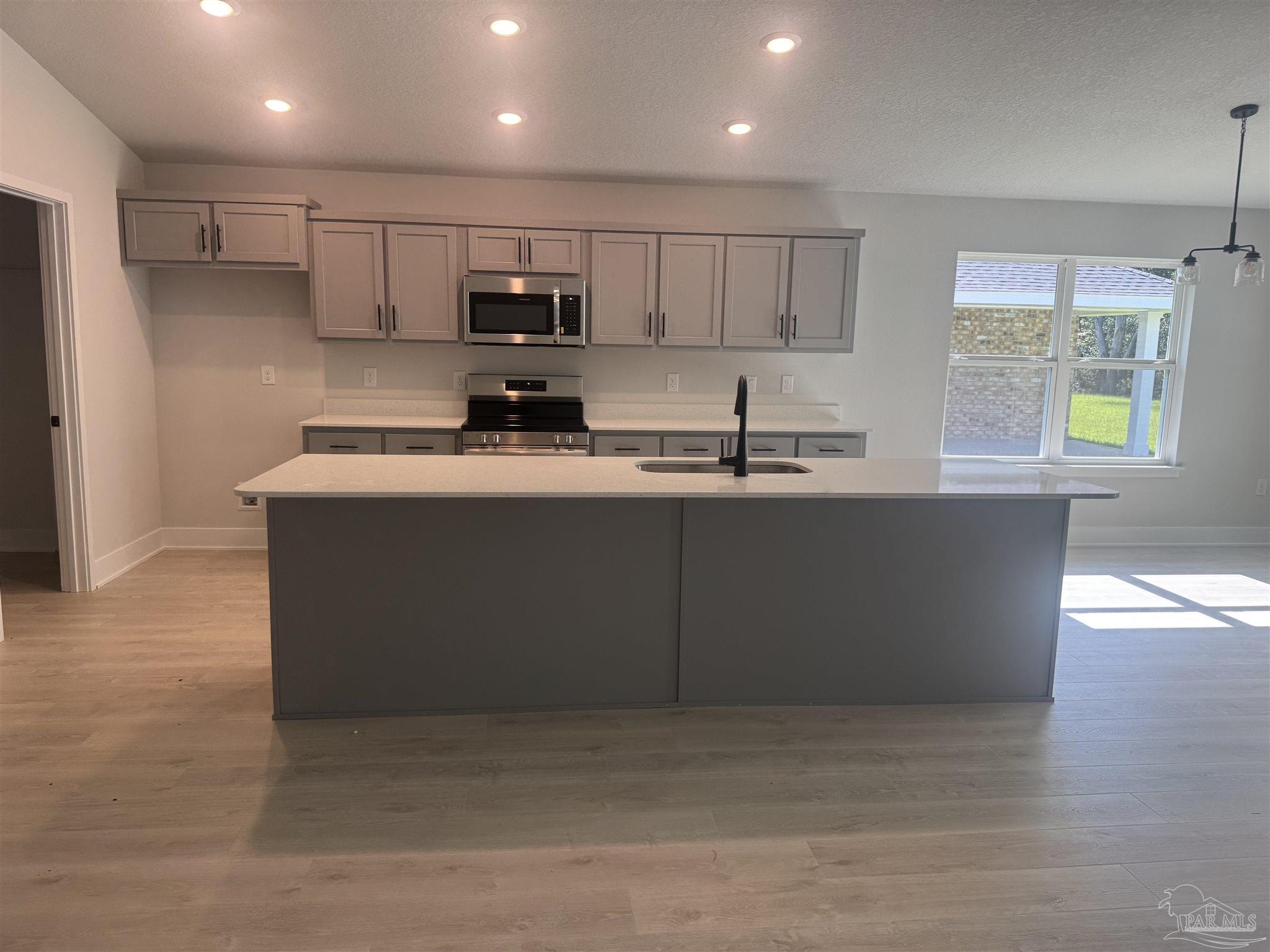 5311 Hidden Pines Circle Milton, FL 32583 - Photo 2 of 7 a kitchen with stainless steel appliances granite countertop a sink a stove a refrigerator a center island and a window