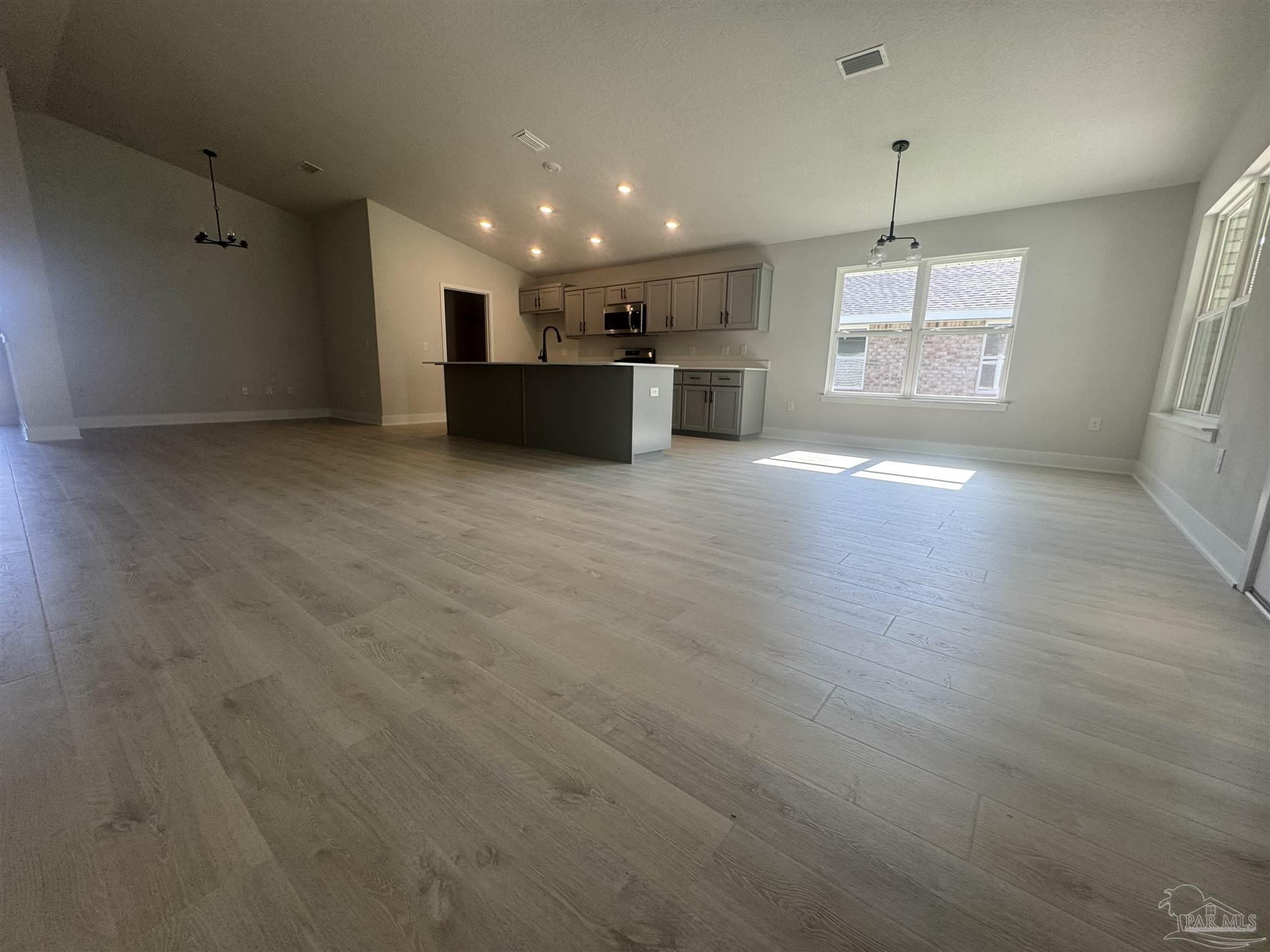 5311 Hidden Pines Circle Milton, FL 32583 - Photo 3 of 7 an empty room with wooden floor and windows