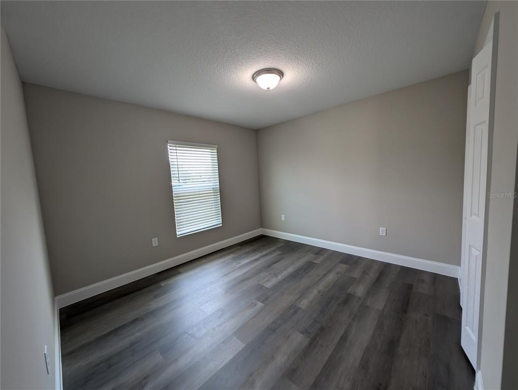 1225 Vanderway Lane Lady Lake, FL 32159 - Photo 5 of 13 a view of an empty room with wooden floor and window
