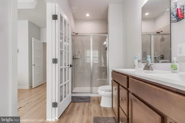 a bathroom with a shower sink vanity mirror and toilet