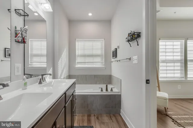 a bathroom with a tub sink and mirror