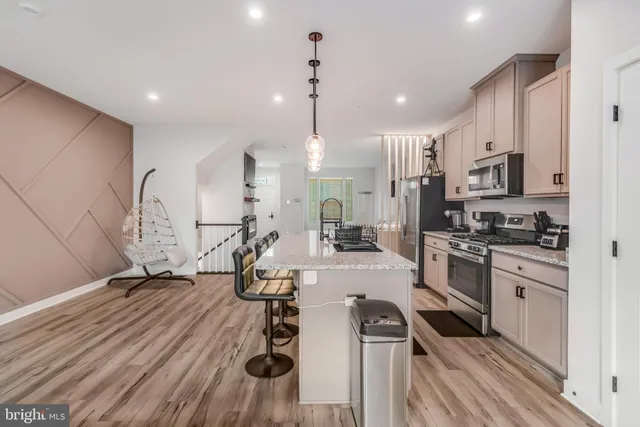 a view of a kitchen with kitchen island white cabinets and stainless steel appliances