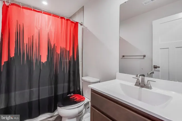 a bathroom with a sink a toilet and shower curtain