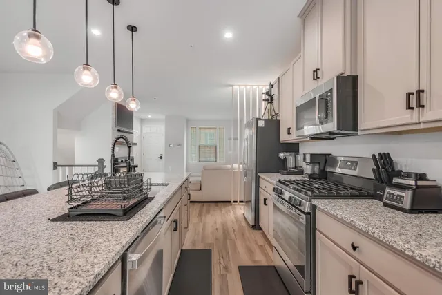a kitchen with stainless steel appliances granite countertop a stove a sink and a granite counter tops
