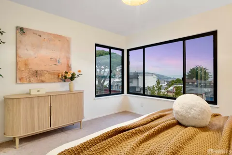 a bedroom with a large bed and a painting on the wall