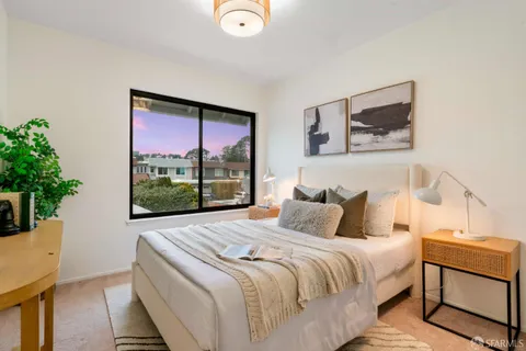 a bedroom with a bed and a painting on the wall