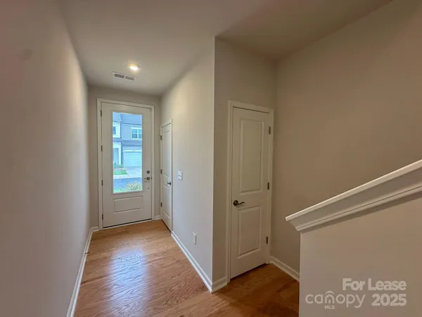 a view of hallway with closet and wooden floor