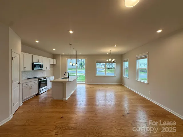 a view of kitchen with microwave a stove and wooden floor