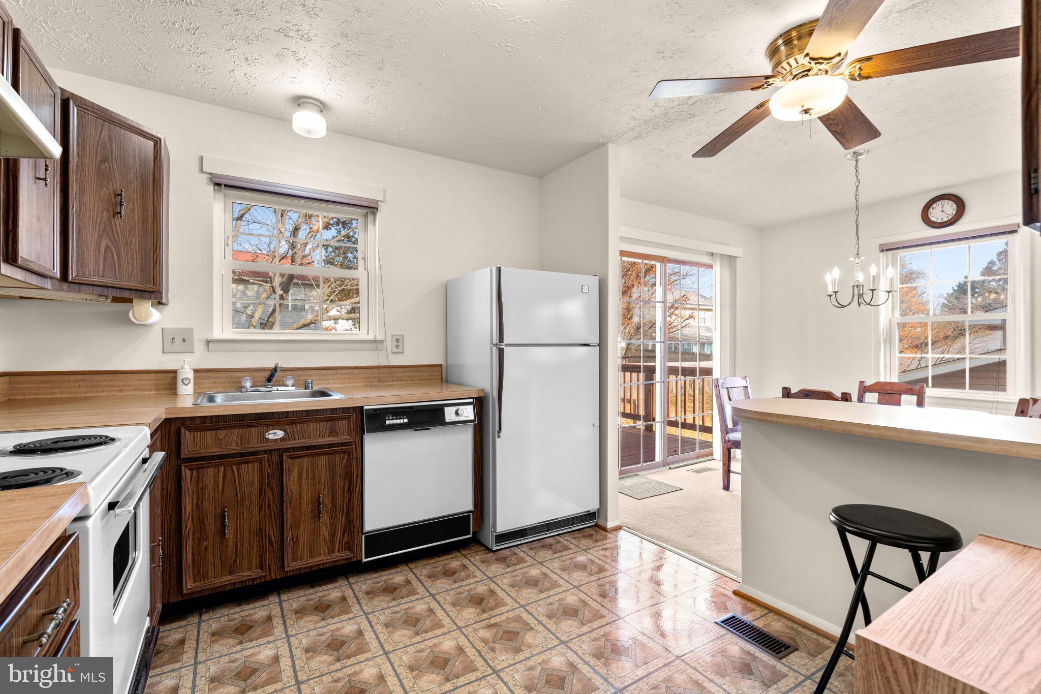 1818 Lasalle Place Severn, MD 21144 - Photo 12 of 30 a kitchen with stainless steel appliances granite countertop a stove top oven a sink a dining table and chairs with wooden floor