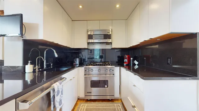 a living room with stainless steel appliances kitchen island furniture and a view of kitchen