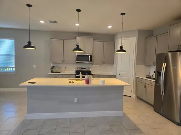 a view of a hallway with stainless steel appliances