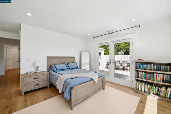a bedroom with a bed a book shelf and a window