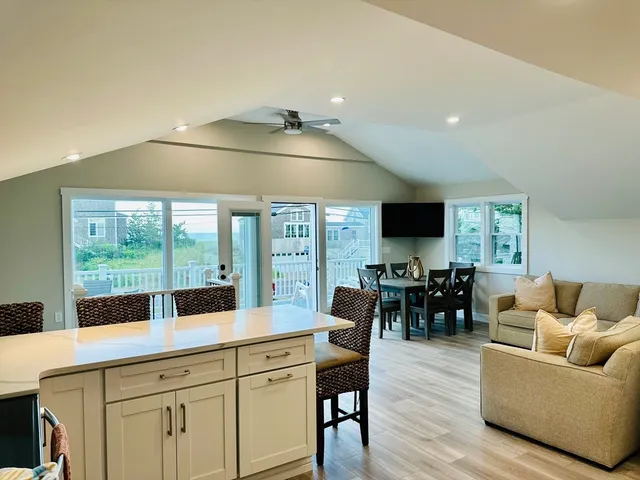 a living room with furniture a flat screen tv and floor to ceiling window