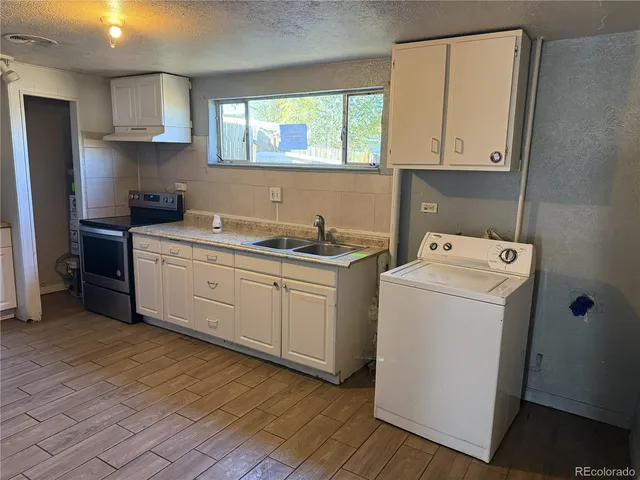 a kitchen with a sink a stove and cabinets