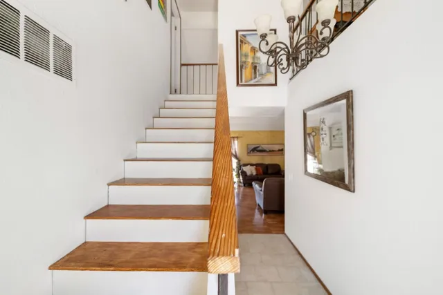 a view of staircase with white walls and a painting on the wall