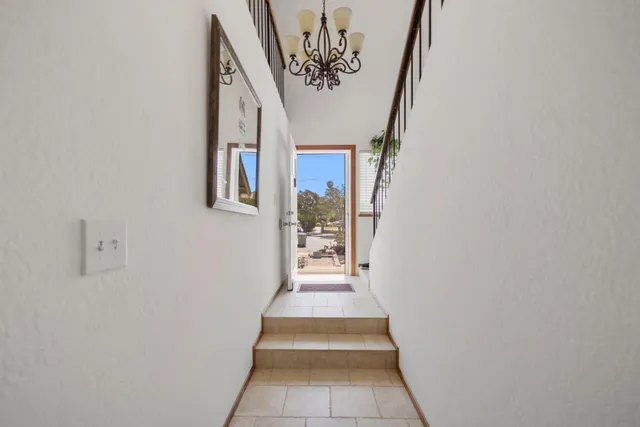 a view of a hallway with wooden floor and windows