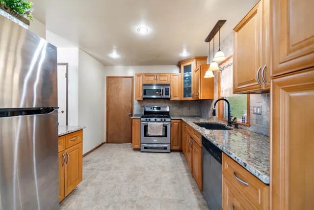 a kitchen with granite countertop a refrigerator and a stove