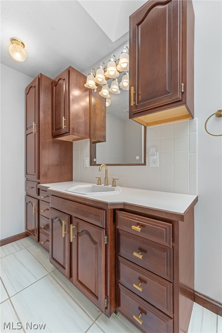 2941 Copley Road Akron, OH 44321 - Photo 25 of 44 Bathroom featuring tasteful backsplash, vanity, and light tile patterned floors