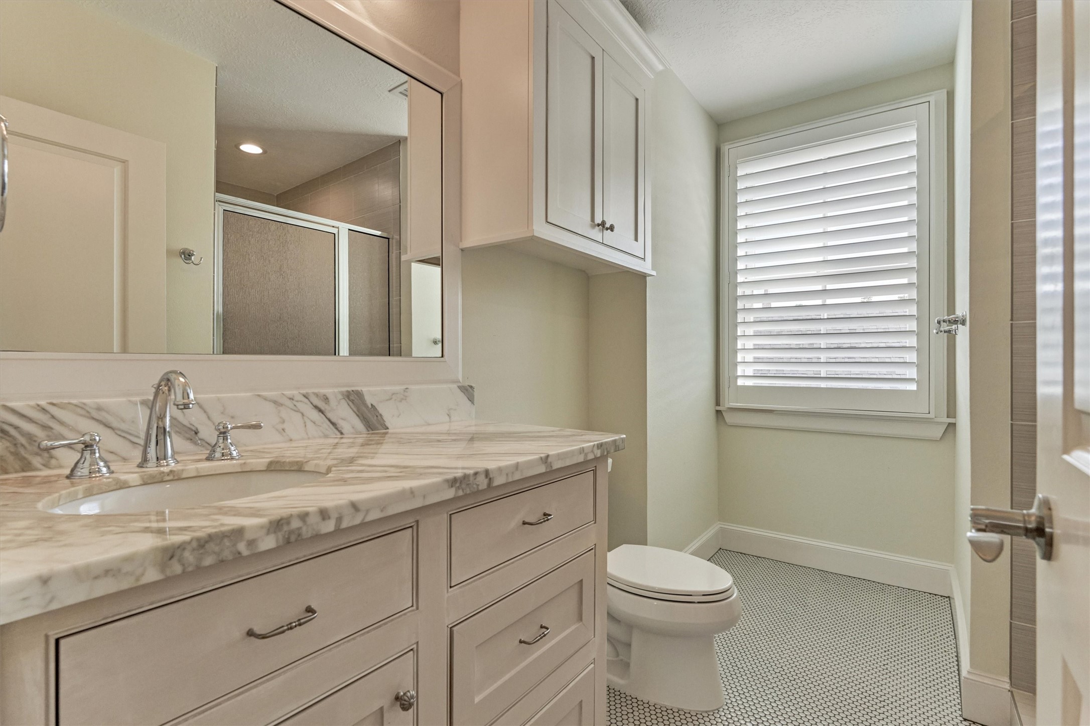 22 East Shore Drive The Woodlands, TX 77380 - Photo 37 of 50 The Guest Quarteres ensuite Bathroom has recently been updated with designer penny tiles, paint, and lighting.