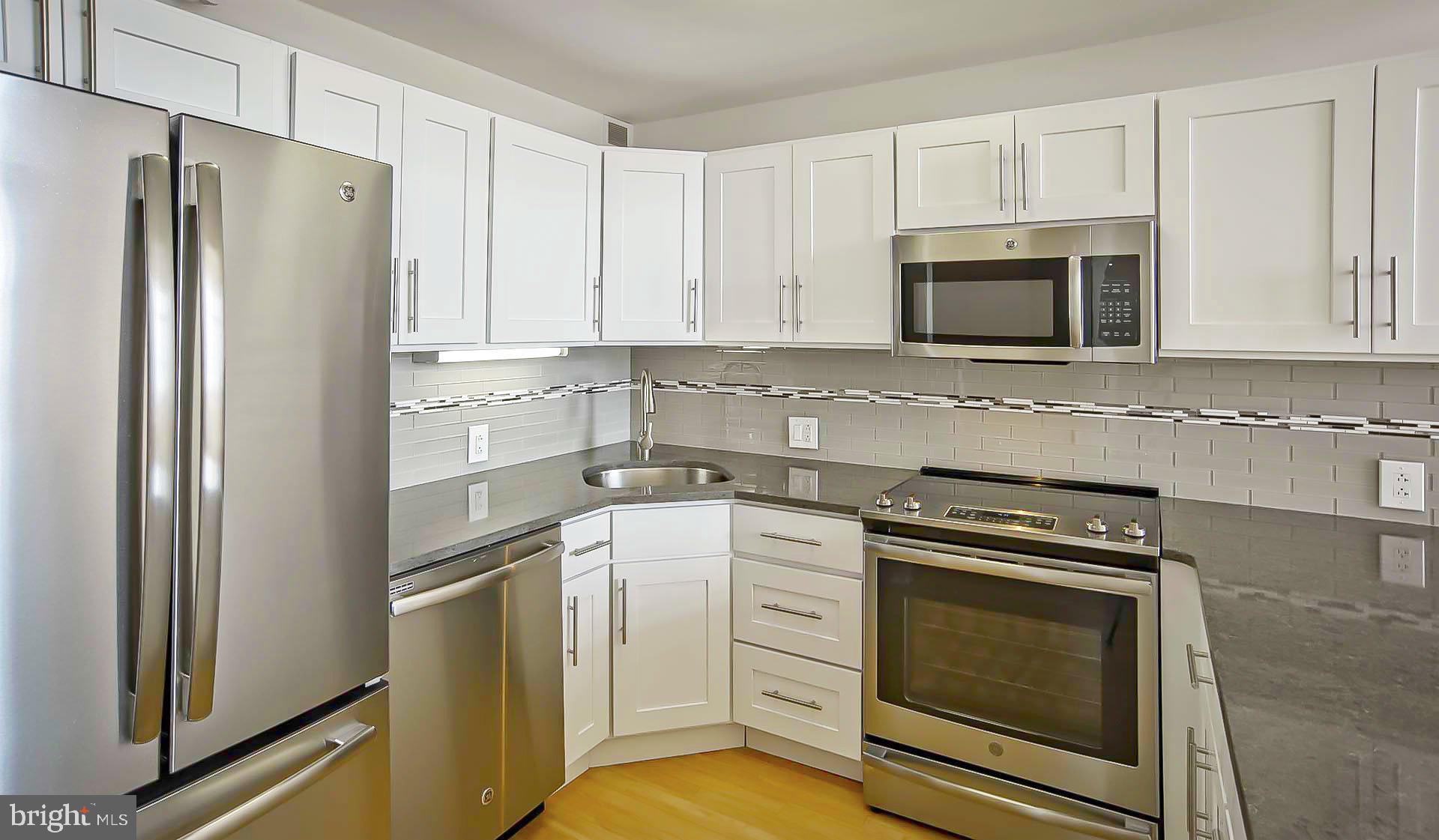 2300 Walnut Street, Unit 228 Philadelphia, PA 19103 - Photo 19 of 27 a kitchen with white cabinets and stainless steel appliances