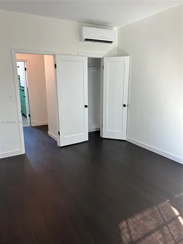 an empty room with wooden floor and closet