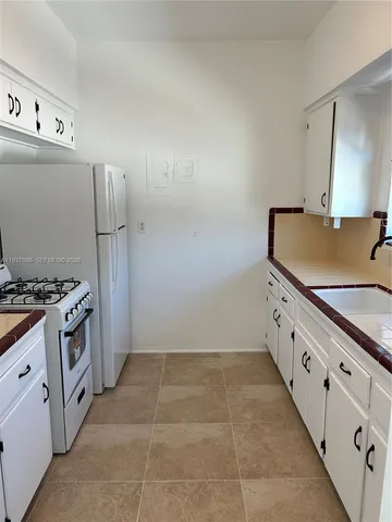 a kitchen with granite countertop a sink and a stove