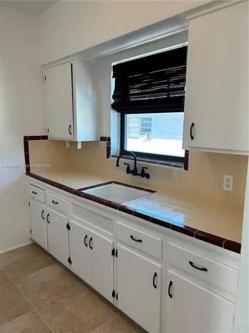 a sink with white cabinets