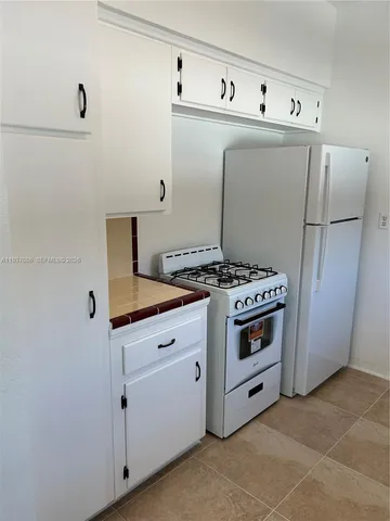 a kitchen with cabinets and white stove