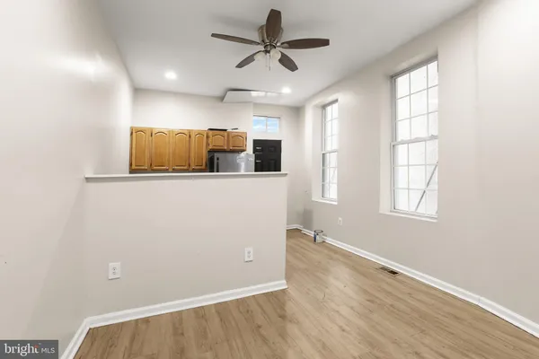 a kitchen that has a microwave a stove and white cabinets with wooden floor