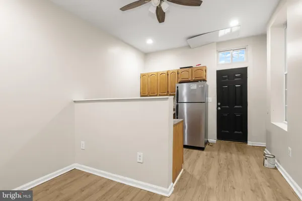 an empty room with chandelier fan and windows