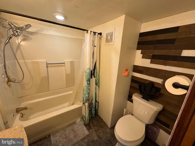 a bathroom with a tub sink shower and mirror