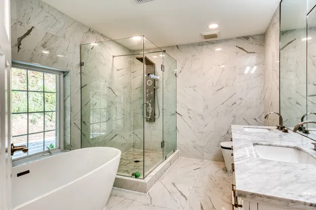 a bathroom with a tub sink toilet and shower