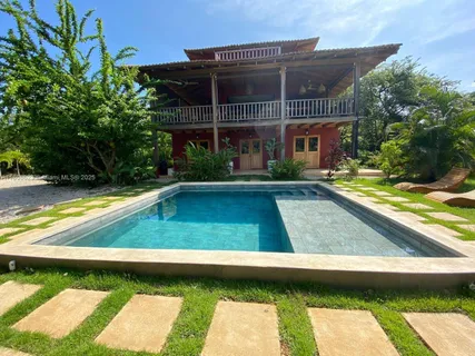 a view of swimming pool with lawn chairs and plants