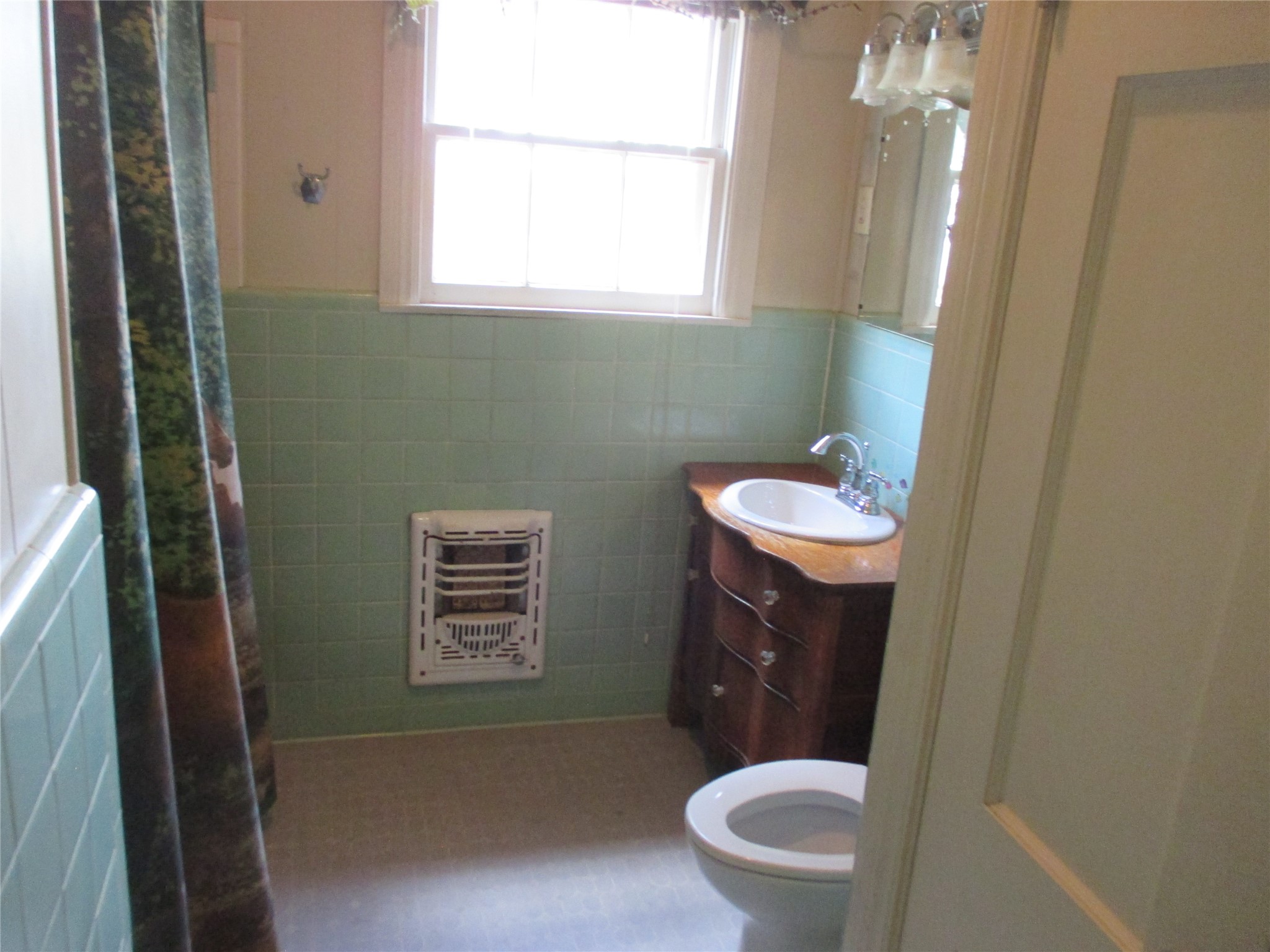 12610 Pecan School Road Bartlett, TX 76511 - Photo 14 of 21 A well-lit bathroom featuring charming pastel tile work and a classic vanity.