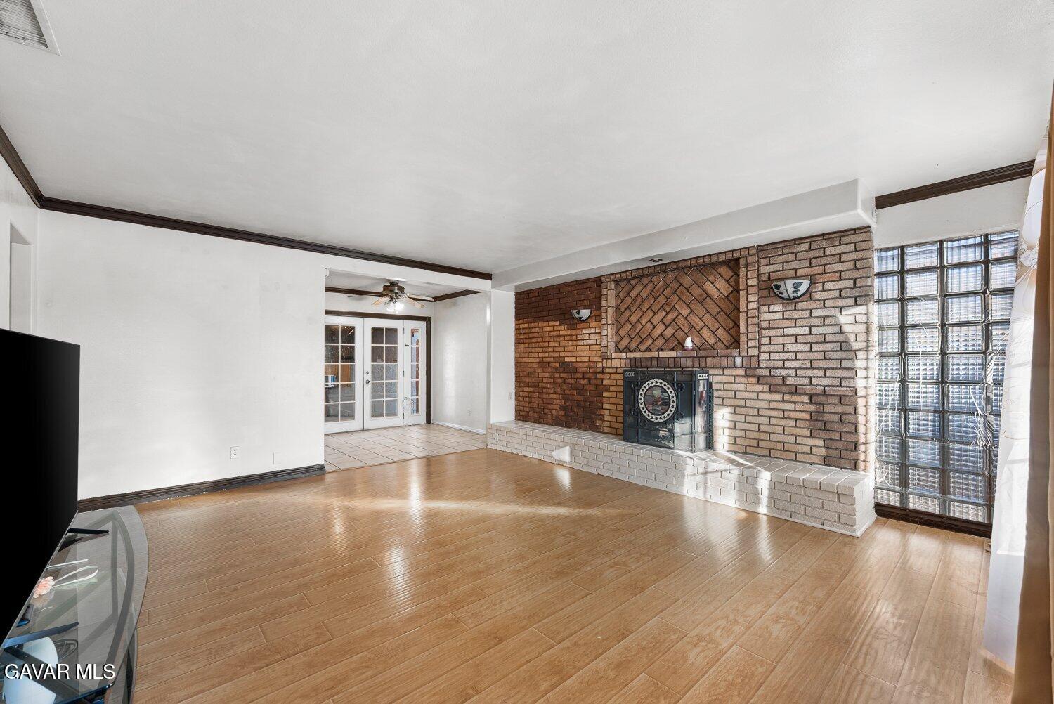 44221 4th Street East Lancaster, CA 93535 - Photo 5 of 68 a view of an empty room with a window and wooden floor