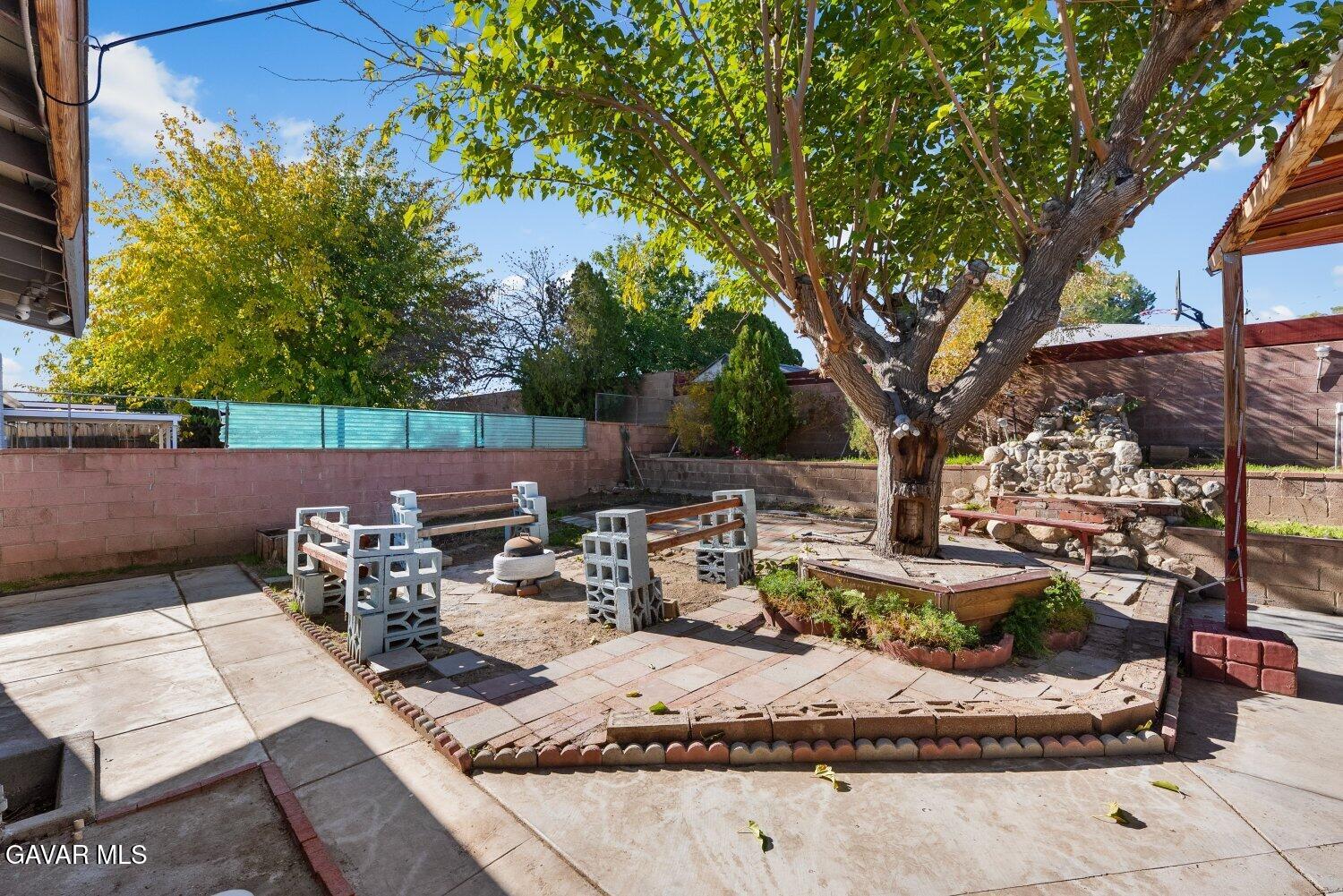 44221 4th Street East Lancaster, CA 93535 - Photo 54 of 68 a view of a patio with table and chairs and a fire pit