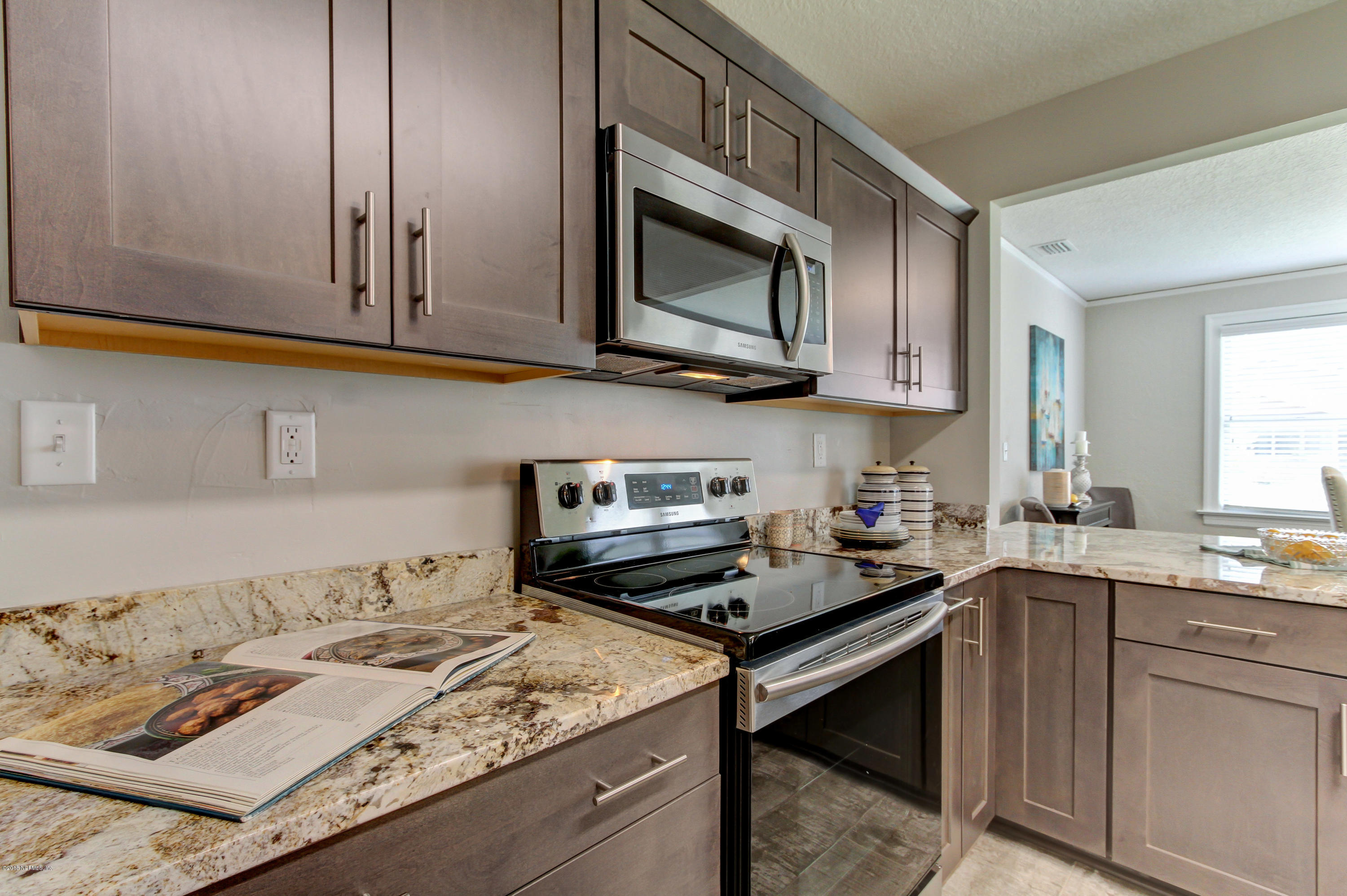 1026 Riviera Street Jacksonville, FL 32207 - Photo 20 of 48 a kitchen with stainless steel appliances granite countertop a sink stove and microwave