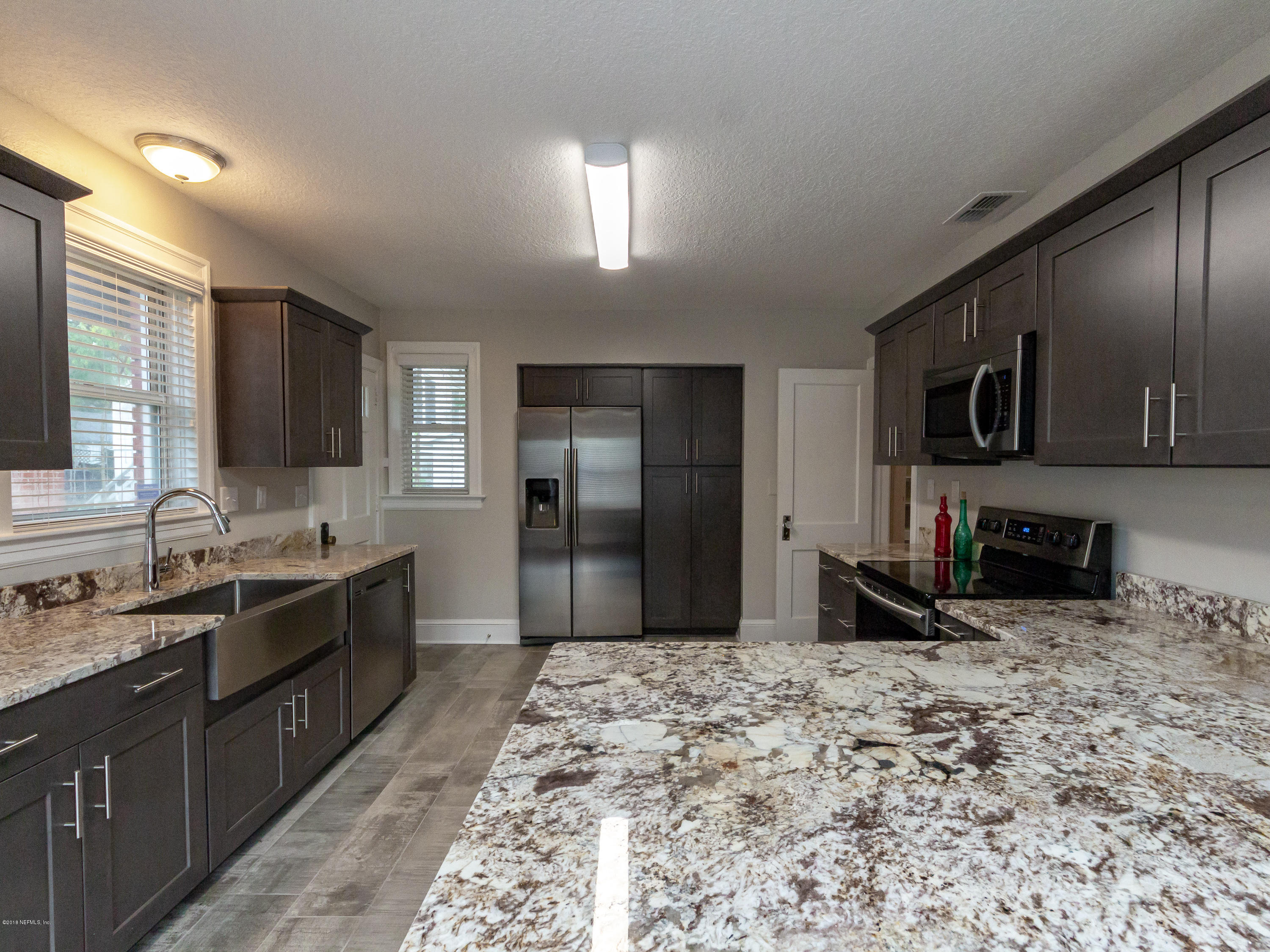 1026 Riviera Street Jacksonville, FL 32207 - Photo 22 of 48 a large kitchen with kitchen island granite countertop a sink refrigerator and microwave