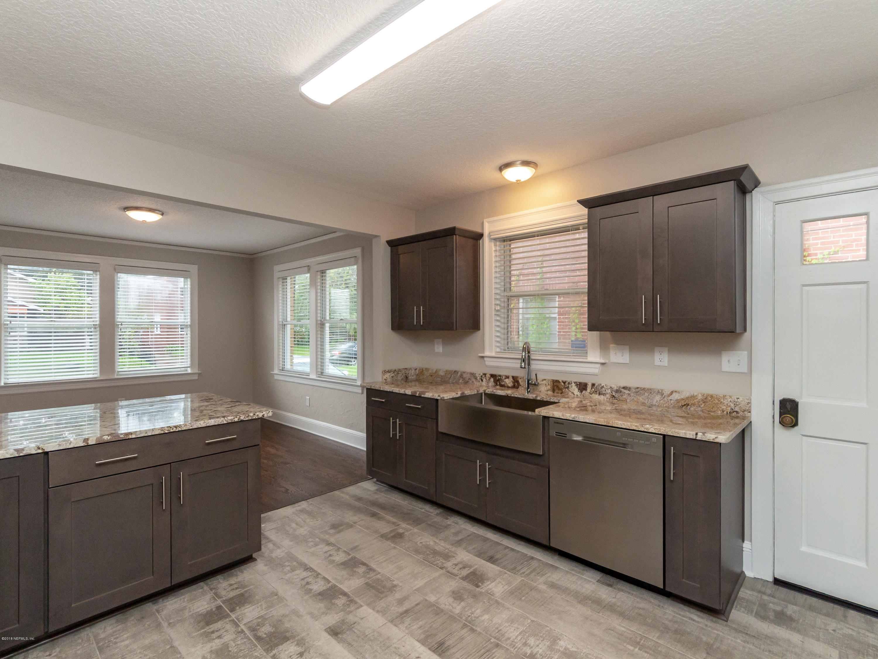 1026 Riviera Street Jacksonville, FL 32207 - Photo 26 of 48 a large kitchen with granite countertop a sink and dishwasher a oven with wooden cabinets