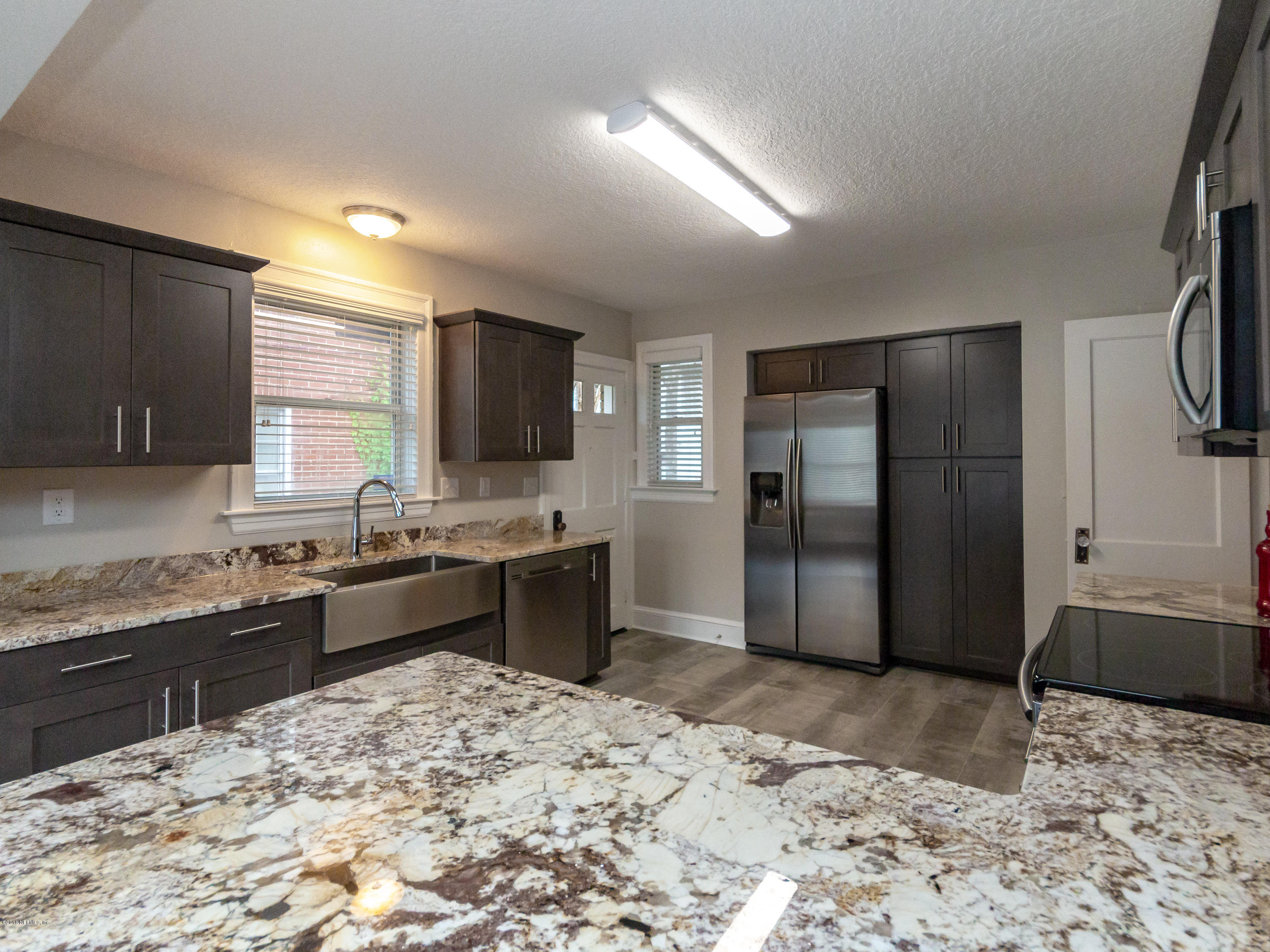 1026 Riviera Street Jacksonville, FL 32207 - Photo 27 of 48 a kitchen with stainless steel appliances granite countertop a refrigerator and a stove top oven
