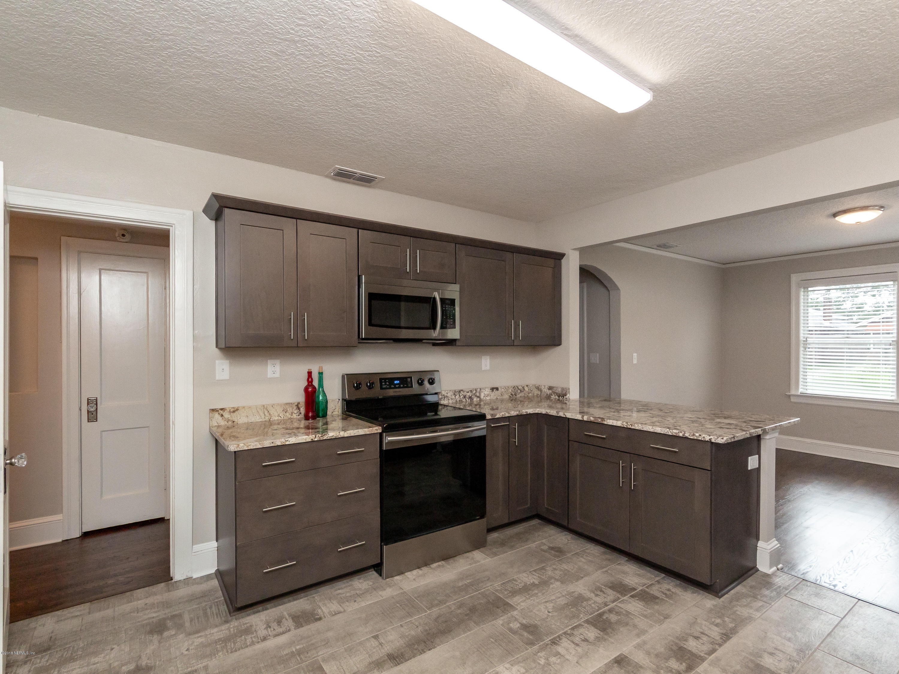 1026 Riviera Street Jacksonville, FL 32207 - Photo 28 of 48 a kitchen with stainless steel appliances granite countertop a sink and a stove top oven