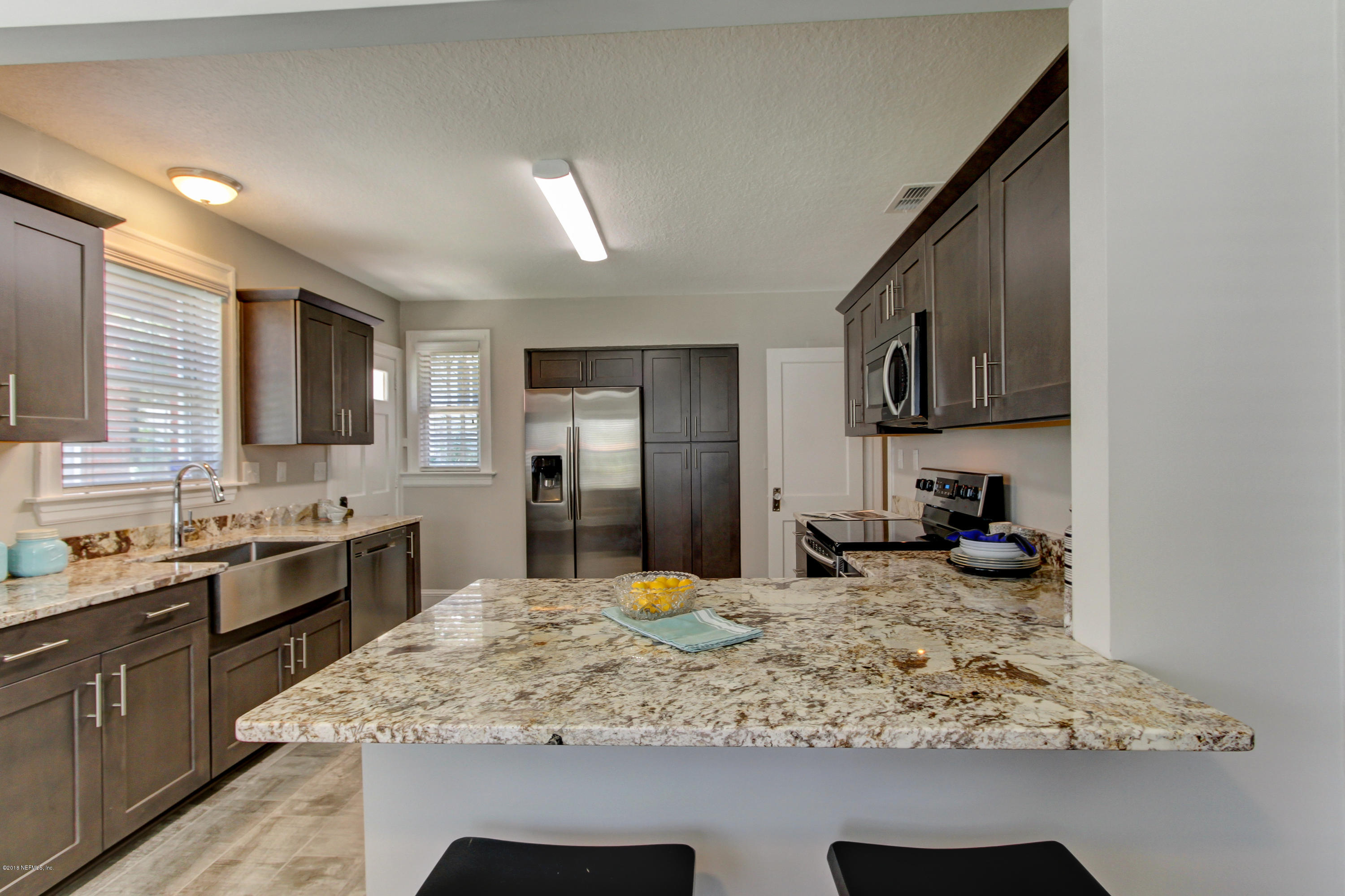 1026 Riviera Street Jacksonville, FL 32207 - Photo 30 of 48 a kitchen with stainless steel appliances granite countertop sink stove top oven and refrigerator