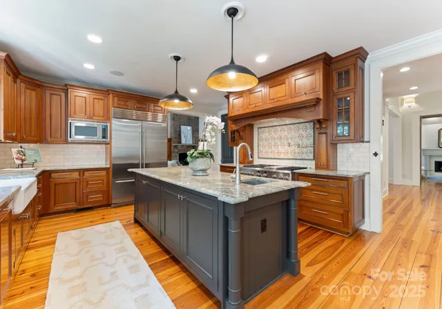 a kitchen with kitchen island granite countertop a stove and a sink