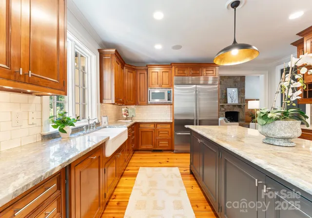 a large kitchen with kitchen island granite countertop a large counter top and stainless steel appliances