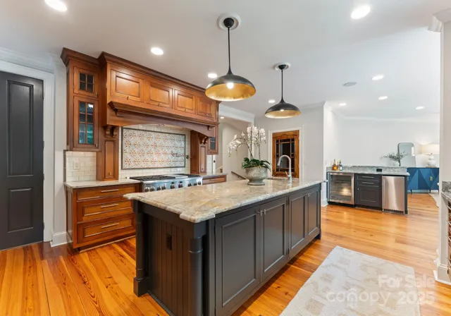 a kitchen with stainless steel appliances granite countertop wooden floors and sink