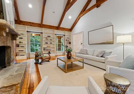 a living room with furniture a fireplace and a floor to ceiling window