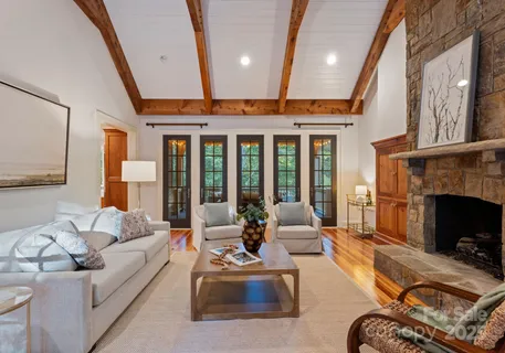 a living room with furniture a fireplace and a large window