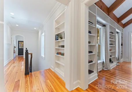 a bedroom with a bed wooden floor and windows