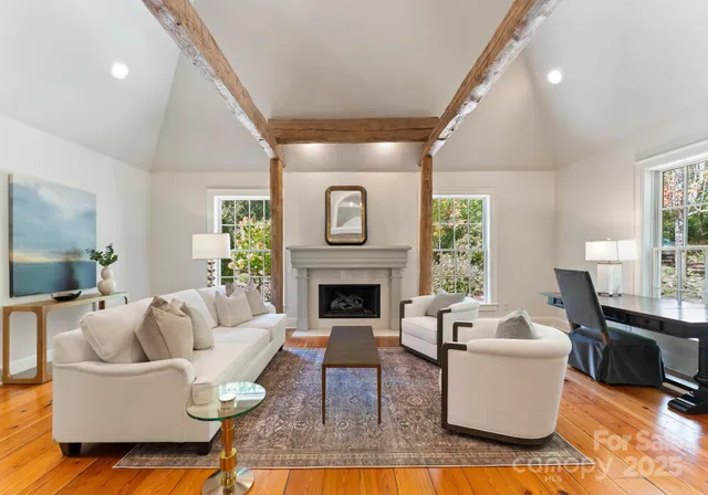 a living room with furniture a fireplace and a large window