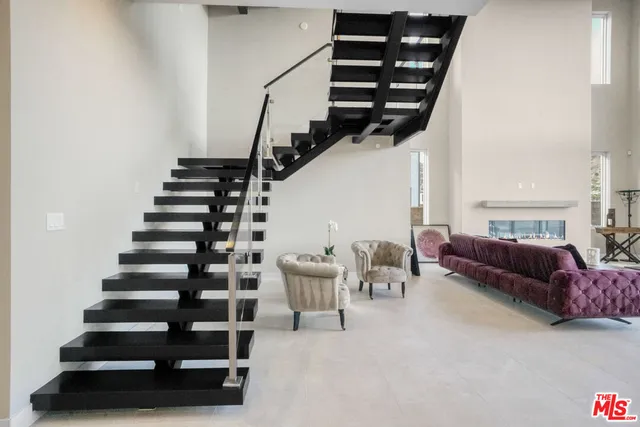 a living room with fireplace furniture and a large window